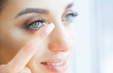 Sağlık ve güzellik. Yeşil gözlü güzel genç kız Kontakt Lens parmağında tutar. Göz bakımı. İyi vizyon Fresh View. Yüksek çözünürlük