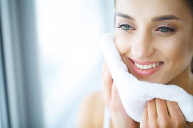 Yüz yıkama. Mutlu kadın cilt havlu ile kurutma