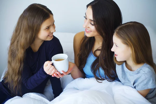 mutlu anne ve çocukları bir yatakta yatarken