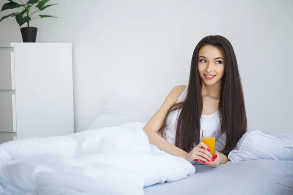 Vrolijke Vrouw Drinken Van Een Jus Orange Zittend Haar Bed — Stockfoto