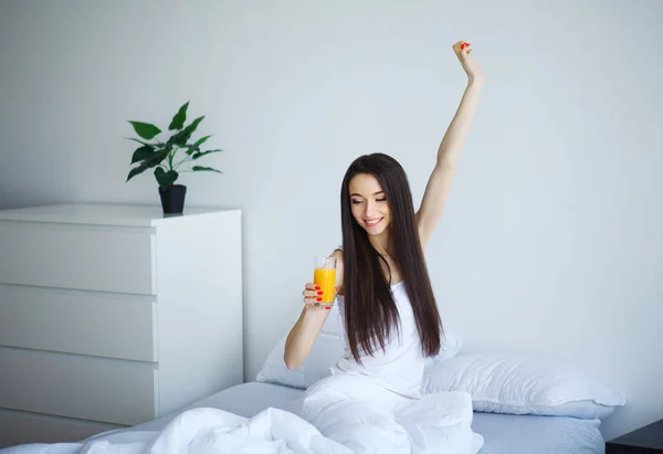 Vrolijke Vrouw Drinken Van Een Jus Orange Zittend Haar Bed — Stockfoto