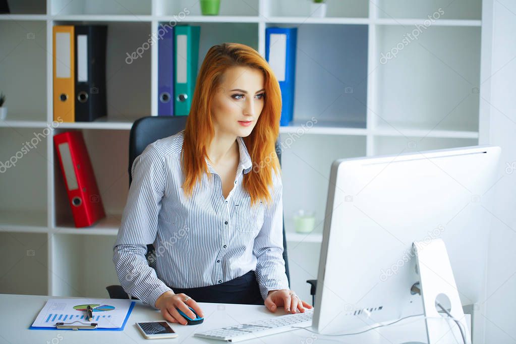 Business. Portrait of a Serious Woman. Business Woman with Red Hair Sits at the Desk in the Big Light Office with a Folder in Hands and Writes. Girl Dressed in White Shirt and Black Skirt.