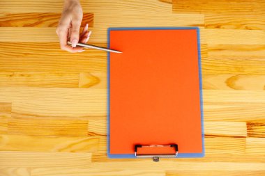 Office el a ağıl ile bir kırmızı renk kağıt ve kalem ahşap masa arka plan üzerinde tutarak. Boşaltmak. Metin için yer.