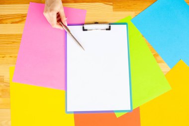 Office el a ağıl ile beyaz renk kağıt ve kalem ahşap masa renkli arka plan üzerinde tutarak. Boşaltmak. Metin için yer.