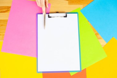 Office el a ağıl ile beyaz renk kağıt ve kalem ahşap masa renkli arka plan üzerinde tutarak. Boşaltmak. Metin için yer.