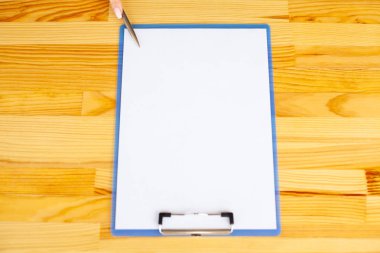 Office el a ağıl ile beyaz renk kağıt ve kalem ahşap masa arka plan üzerinde tutarak. Boşaltmak. Metin için yer.