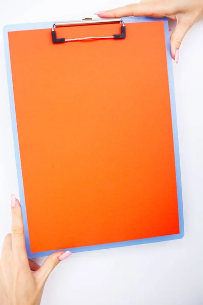 Blank Folder with ?range Paper. Hand that Holding Folder and Handle on White Background. Copyspace. Place for Text.