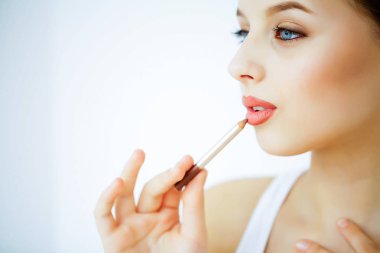 Güzellik ve bakım. Güzel bir cilt ile genç bir kadın portresi. Güzel dudaklar. Kız ruj onun elinde tutan. Güzel mavi gözlü kadın. Makyaj. Dudaklar için bakım