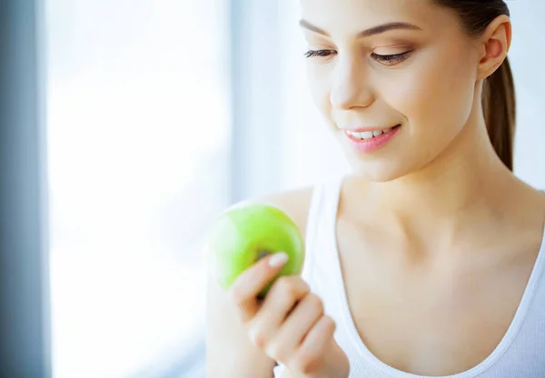 Health and Beauty. Beautiful Young Girl With White Teeth Holding Hands Of Fresh Green Apple. A Woman With A Beautiful Smile. Tooth Health