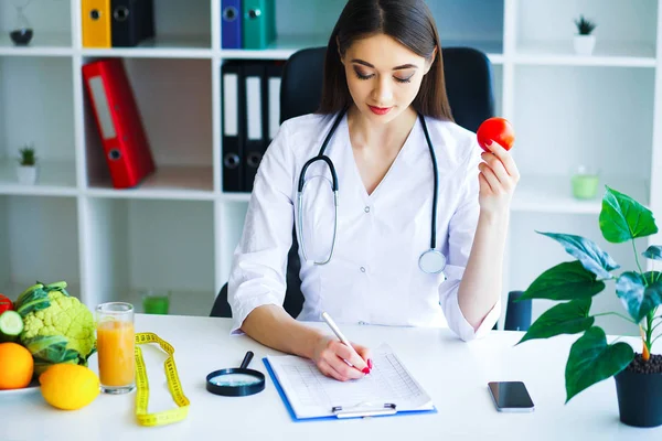 Health. Diet and Healthy. Doctor Dietitian Holding Fresh Tomatoes In Her Hands And Smiles. Beautiful and Young Doctor. High Resolution