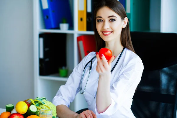 Health. Diet and Healthy. Doctor Dietitian Holding Fresh Tomatoes In Her Hands And Smiles. Beautiful and Young Doctor. High Resolution