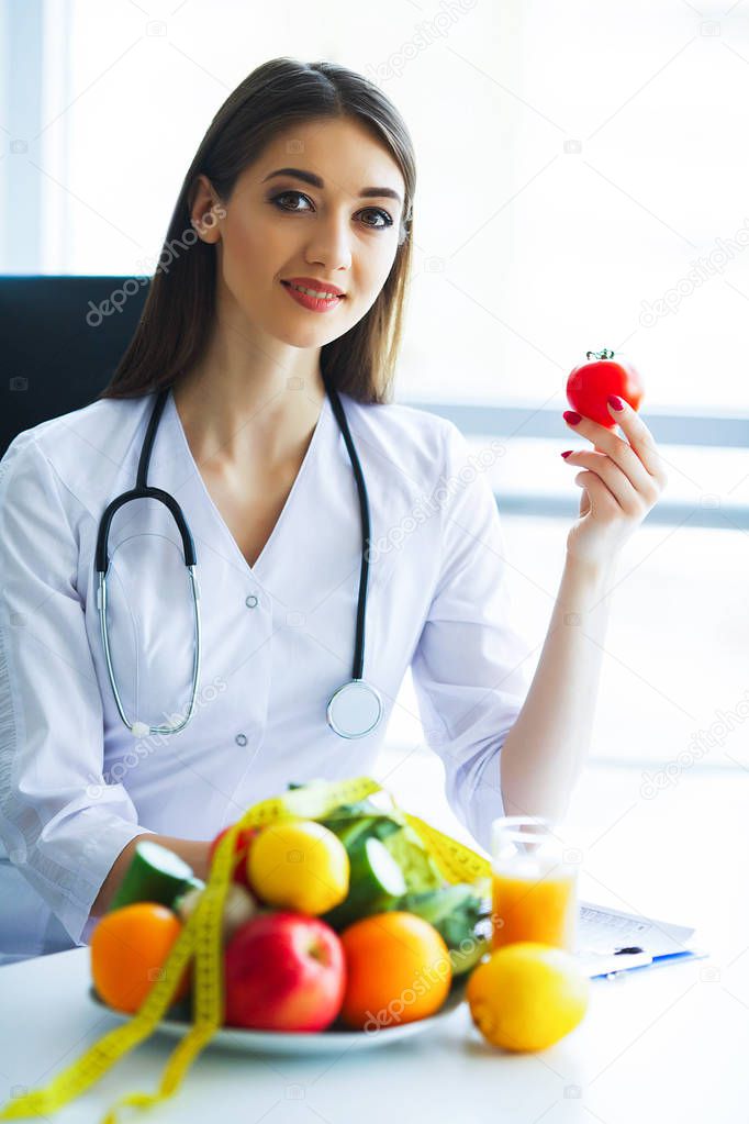 Health. Diet and Healthy. Doctor Dietitian Holding Fresh Tomatoes In Her Hands And Smiles. Beautiful and Young Doctor. High Resolution