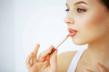 Güzellik ve makyaj. Saf deri ve mavi gözleri olan bir kadın. Güzel genç kız dudakları bir kalem ile çizer. Cilt Bakımı. Yüksek çözünürlük