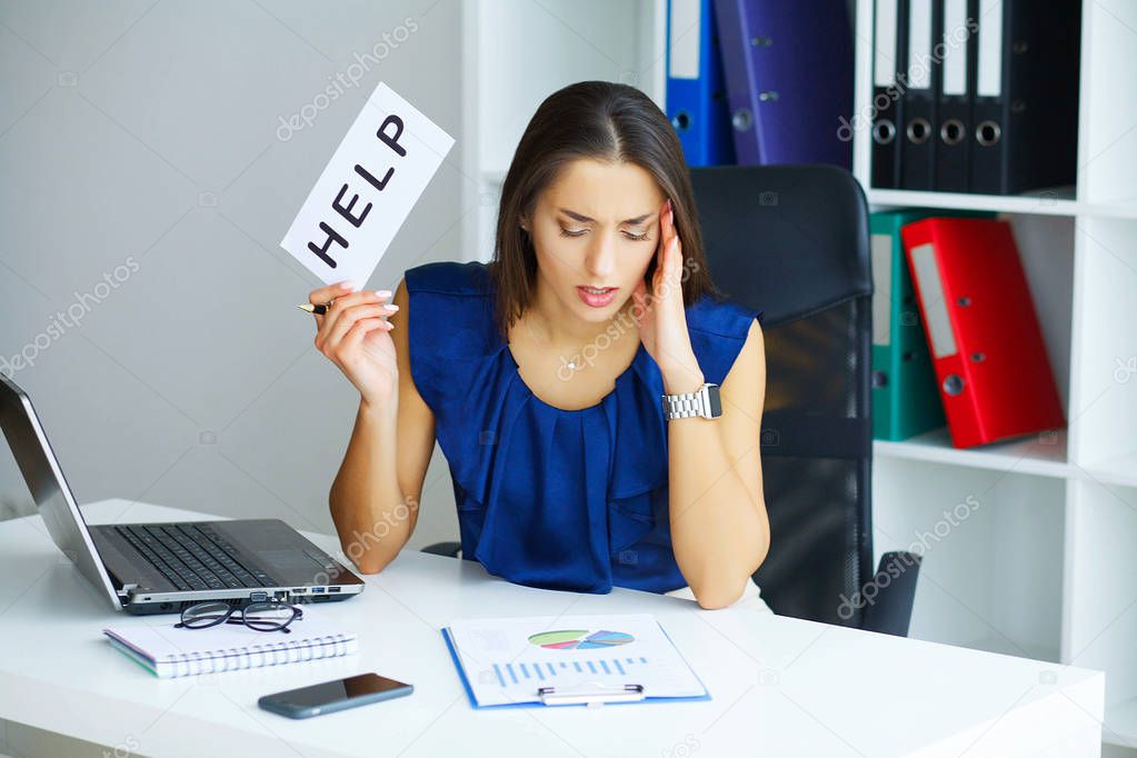 Business. Young Business Girl Sitting At Desk In Light Office And Looks Tired. Woman Dressed in Blue Blouse and Beige Skirt Holding in Hands Inscription Help. High Resolution