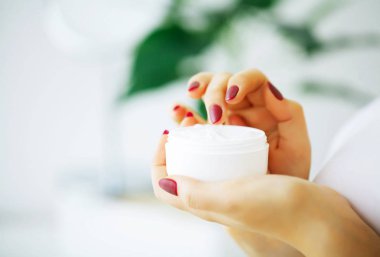 Güzellik ve bakım. Krem yüz eller içinde olan genç kadın. Sabah cilt bakımı. Genç kızla de derisi yüzülmüş. Yüksek çözünürlük