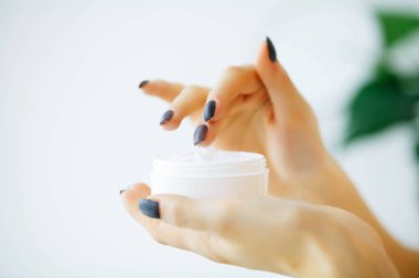 Güzellik ve bakım. Krem yüz eller içinde olan genç kadın. Sabah cilt bakımı. Genç kızla de derisi yüzülmüş. Yüksek çözünürlük