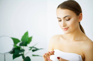 Güzellik ve bakım. Genç kadın için yüz kremi uygulayın. Sabah cilt bakımı. Gri ve saf bir cilt. Yüksek çözünürlük