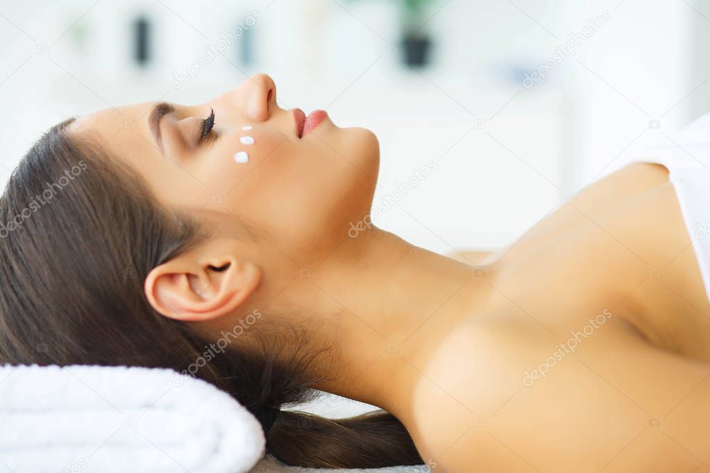 Beauty. Young Girl in Beauty Salon. Brunette Woman with Green Eyes. Lying on the Massage Tables. Clean and Fresh Skin. Skin Care. High Resolution