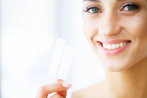 Woman Using Teeth Whitening Strip For Beautiful White Smile. High Resolution Image