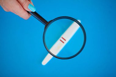 Hamilelik testi ile mavi bir arka plan üzerinde yalan olumlu bir sonuç.