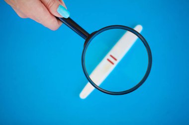 Hamilelik testi ile mavi bir arka plan üzerinde yalan olumlu bir sonuç.