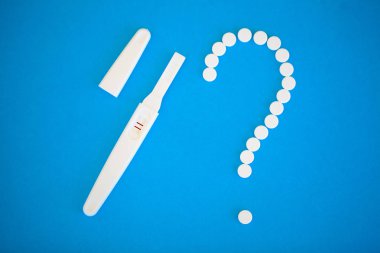 Gebelik planlama concep. Hamilelik testi pozitif iki çizgili ve mavi arka plan üzerinde Doğum kontrol hapı ile.