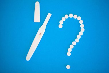 Gebelik planlama concep. Hamilelik testi pozitif iki çizgili ve mavi arka plan üzerinde Doğum kontrol hapı ile.