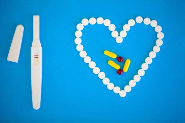 Gebelik planlama concep. Hamilelik testi pozitif iki çizgili ve mavi arka plan üzerinde Doğum kontrol hapı ile.