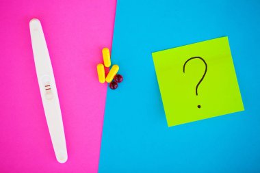 Hamilelik testi. Sonuç olumlu iki şeritler ve prezervatifle gebelik önleyici renkli arka plan, Doğum kontrol hapı, güvenli seks, sağlık concep