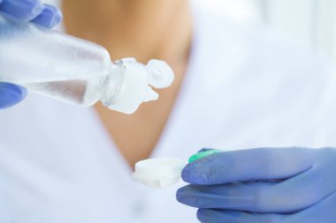 Vizyon ve tıp kavramı. Genç kız göz damlası elinde tutar. Yeşil gözleri ve kontakt lensler ile güzel bir kadın portresi. Sağlıklı bir görünüm. Yüksek çözünürlük