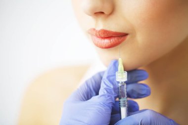 Dudak estetik ameliyat enjeksiyon genç kadının yüzünde