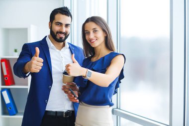 Şirket kavramı işkadını ve ofiste başparmak gösterilmesini işadamı gülümseyen mutlu