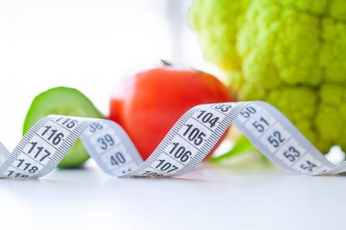 Diyet. Fitness ve sağlıklı gıda diyet kavramı. Dengeli beslenme sebze ile. Beyaz arka plan kasette ölçme taze yeşil sebze. Portre