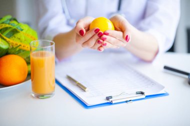 Diyet. Beslenme uzmanı doktor ofisinde limon tutun. Kavramı doğal gıda ve sağlıklı bir yaşam tarzı. Fitness ve sağlıklı gıda diyet kavramı. Dengeli beslenme sebze ile.