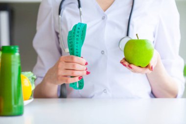 Diyet. Fitness ve sağlıklı gıda diyet kavramı. Dengeli beslenme sebze ile. Yeşil elma ofisinde ölçme neşeli Doktor beslenme uzmanı portresi. Doğal gıda ve sağlıklı yaşam kavramı.