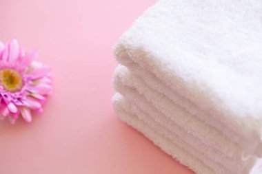 Spa. Beyaz Pamuk Spa banyo pembe bir arka plan üzerinde kullanımda havlu. Havlu kavramı. Otel ve masaj salonları için fotoğraf. Saflık ve yumuşaklık. Havlu Tekstil.
