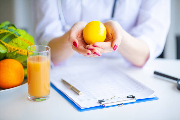Диета. Доктор Нутриционист держит лимон в своем кабинете. Концепция натурального питания и здорового образа жизни. Концепция здорового питания. Сбалансированное питание с овощами
.