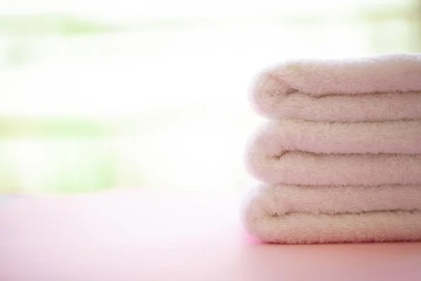 在粉红色的背景上滚动白色的身体毛巾 毛巾的概念 酒店和按摩院的照片 纯度和柔软度 毛巾纺织品 — 图库照片