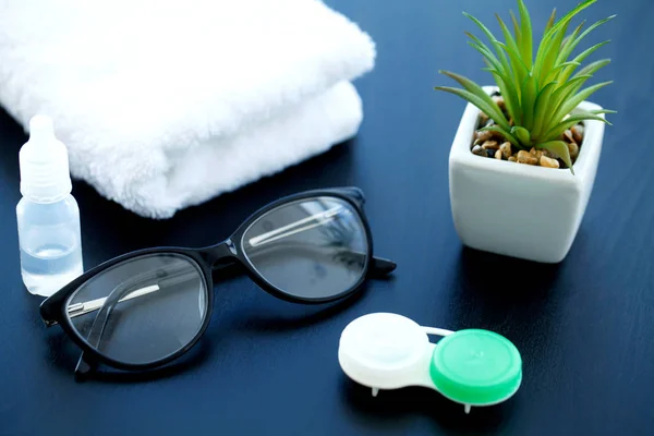 Glasses and objects for cleaning and storing contact lenses, to improve vision, on a black background