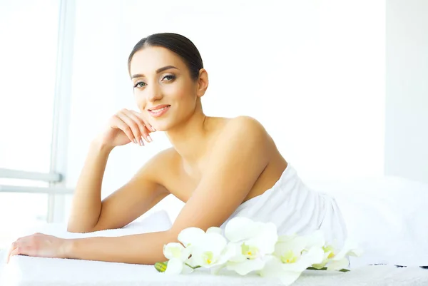 Spa day. Happy positive woman looking at you while enjoying her rest in the spa salon