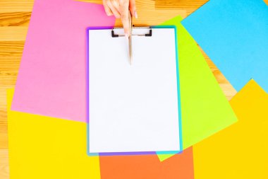 Bir klasörü bir mavi renk kağıt ve kalem ahşap masa renkli arka plan üzerinde tutan office el. Boşaltmak. Te yer