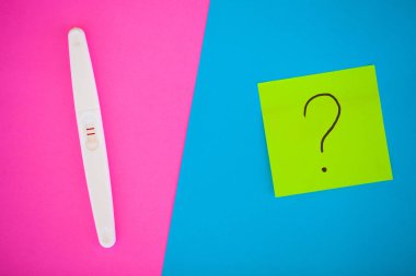 Hamilelik testi. Sonuç olumlu iki şeritler ve prezervatifle gebelik önleyici renkli arka plan, Doğum kontrol hapı, güvenli seks, sağlık concep.