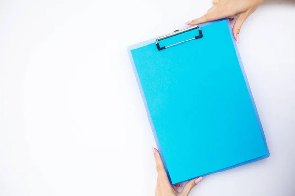 Blank Folder with Blue Paper. Hand that Holding Folder and Pen on White Background. Copyspace. Place for Text.