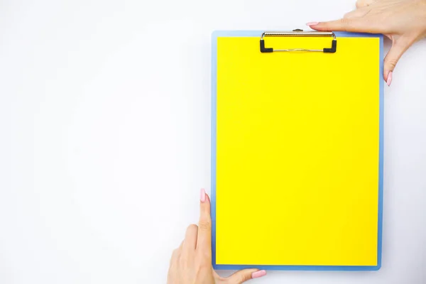 Blank Folder with Yellow Paper. Hand that Holding Folder and Handle on White Background. Copyspace. Place for Text.