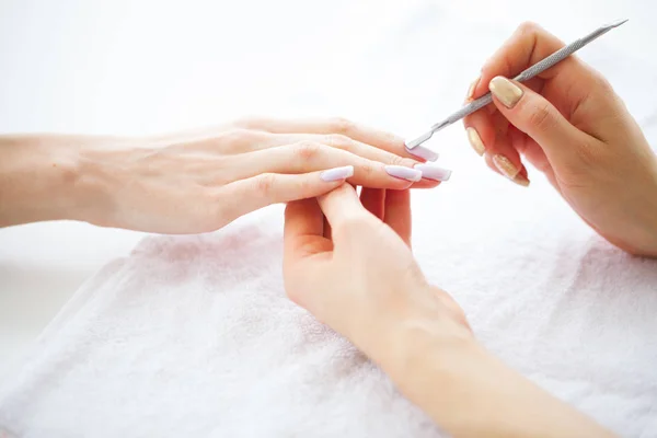 SPA manicure. French manicure at spa salon. Woman hands in a nail salon receiving a manicure procedure. Manicure procedure.