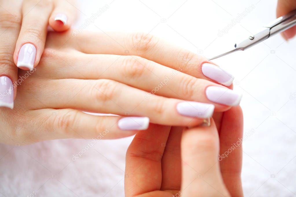 SPA manicure. French manicure at spa salon. Woman hands in a nail salon receiving a manicure procedure. Manicure procedure.