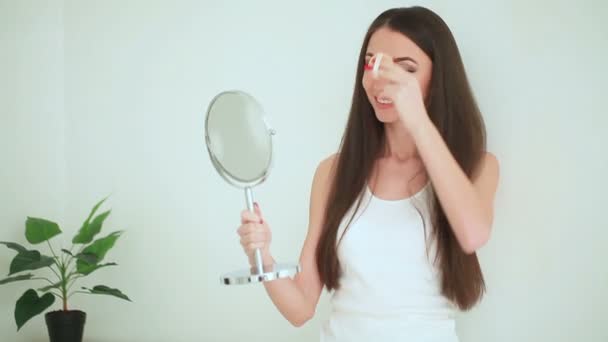 Schoonheid en verzorging. Vrouw toepassen crème op de huid. Mooie jonge vrouw met schone frisse huid aanraken haar gezicht. Gezichtsbehandeling. Cosmetologie, schoonheid en Wellness — Stockvideo