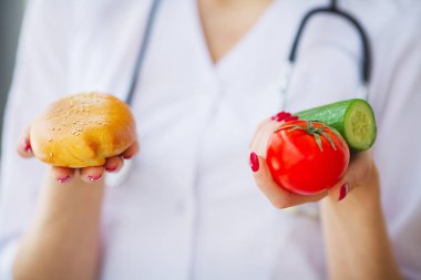 Diyet. Patty ve taze sebzeler arasında bir seçim veren doktor kadın portre.