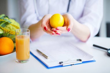 Diyet. Beslenme uzmanı doktor ofisinde limon tutun. Kavramı doğal gıda ve sağlıklı bir yaşam tarzı. Fitness ve sağlıklı gıda diyet kavramı. Dengeli beslenme sebze ile.