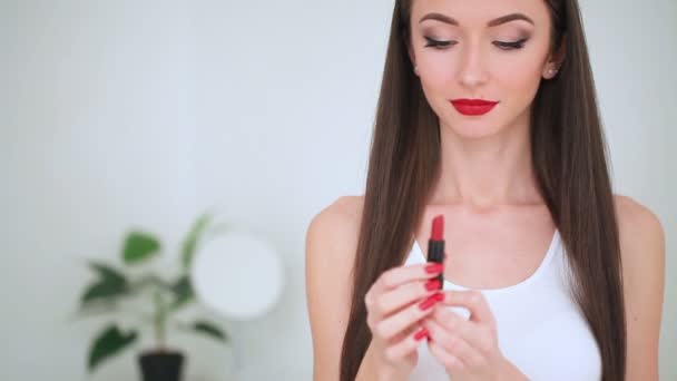 Make-up. schöne Brünette trägt Lippenstift auf. — Stockvideo